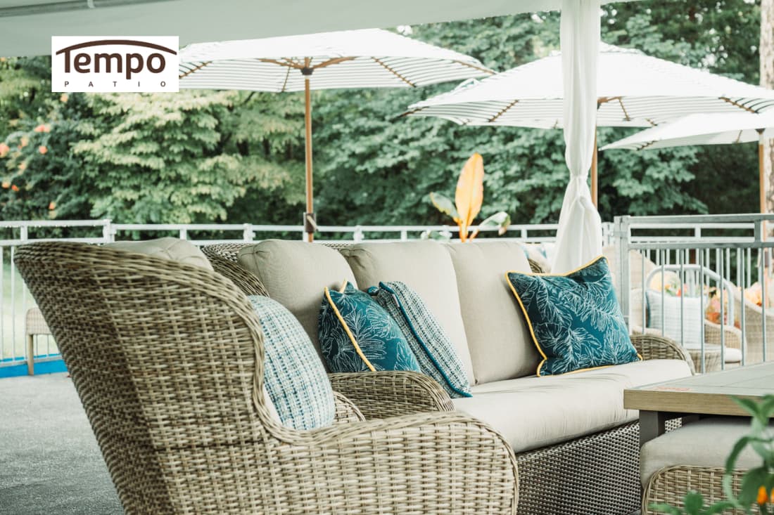 Wicker patio seating beneath striped umbrellas, showcasing semi-permanent & fixed umbrella setups