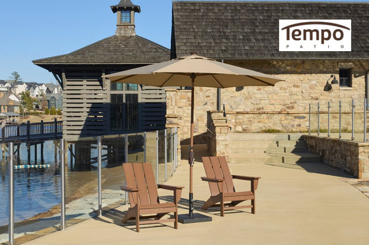 Anchored patio umbrella systems for patios shading Adirondack chairs beside a lakeside boathouse.