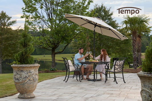 Couple toasting under a large umbrella shows permanent patio umbrella solutions for homes with lakeside views. 