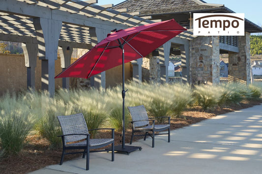 Permanent shade patio umbrella buying tips featuring a red cantilever umbrella beside ornamental grasses.