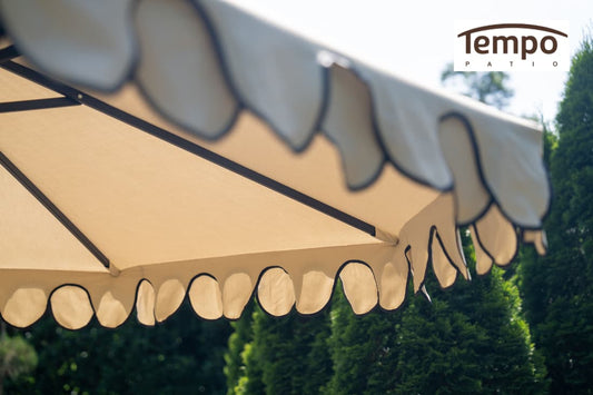 Semi-permanent umbrella options overview close-up of a scalloped canopy edge against green hedges.